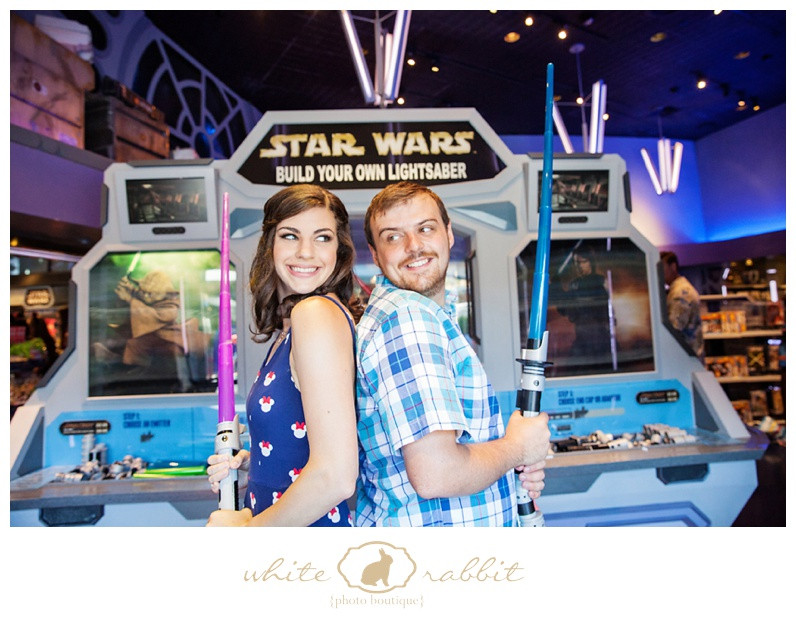 A couple shares a laugh while sitting on a bench with a futuristic background in Tomorrowland at Disneyland.