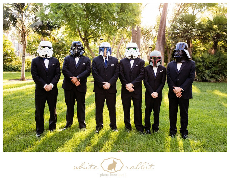 Groomsmen dressed as Stormtroopers pose for a photo at a wedding.
