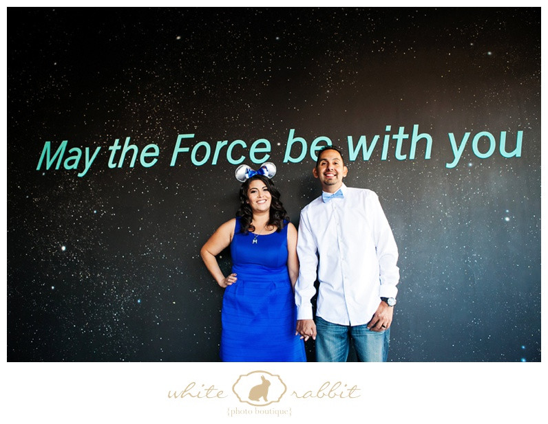 A couple poses playfully with lightsabers in a Star Wars themed engagement photo shoot.