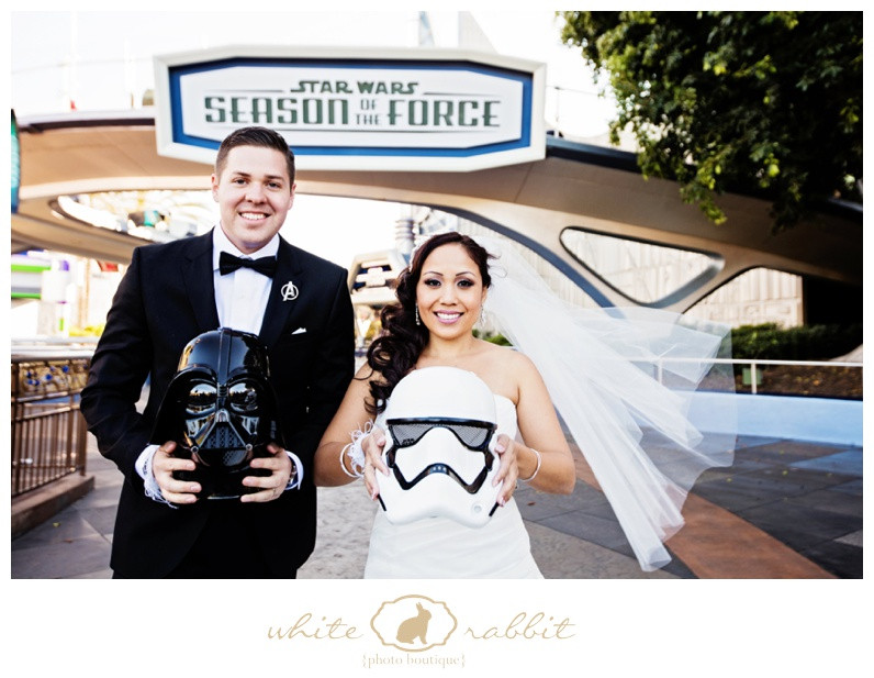 A groom poses for a dramatic portrait with a lightsaber in a Star Wars themed wedding photo.