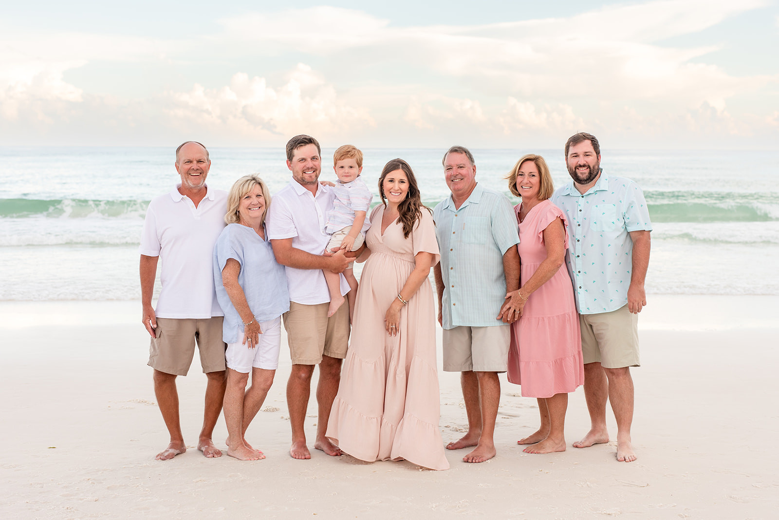 Family in coastal colors on the beach at sunset