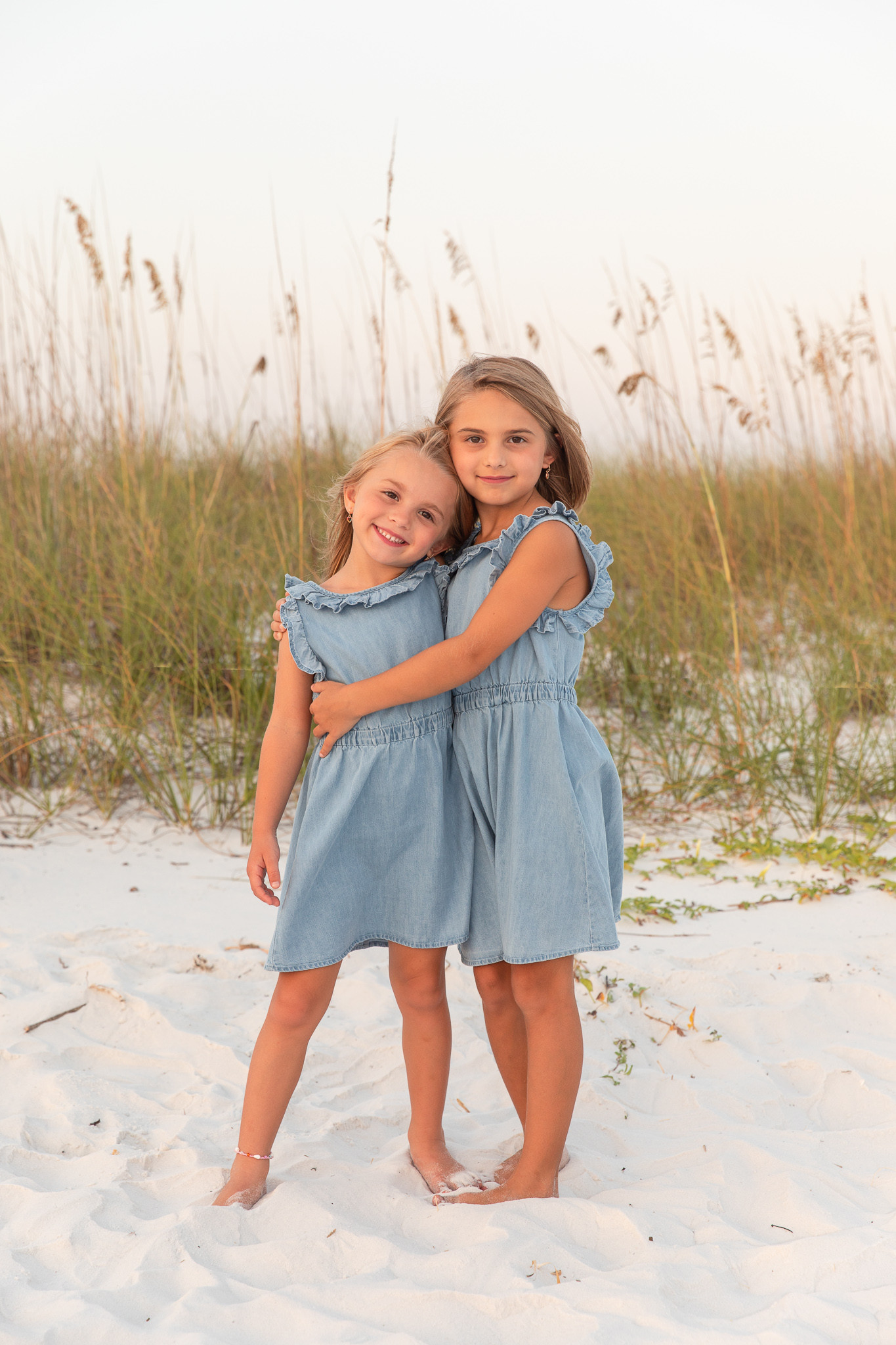 alt text: Two brothers wear coordinating shirts and different colored shorts on the beach.