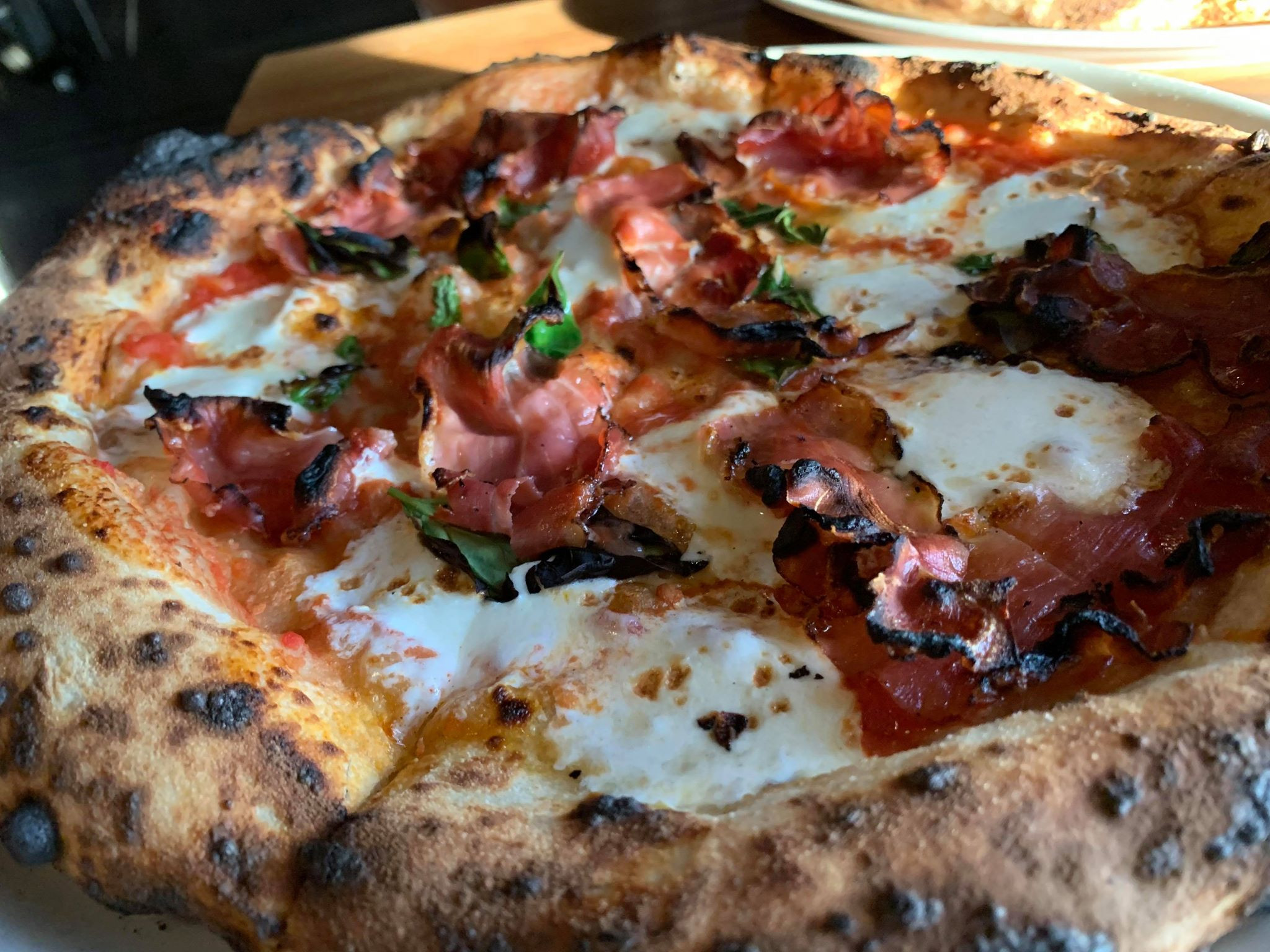 A Dopo Ham pizza showcasing the toppings and sourdough crust