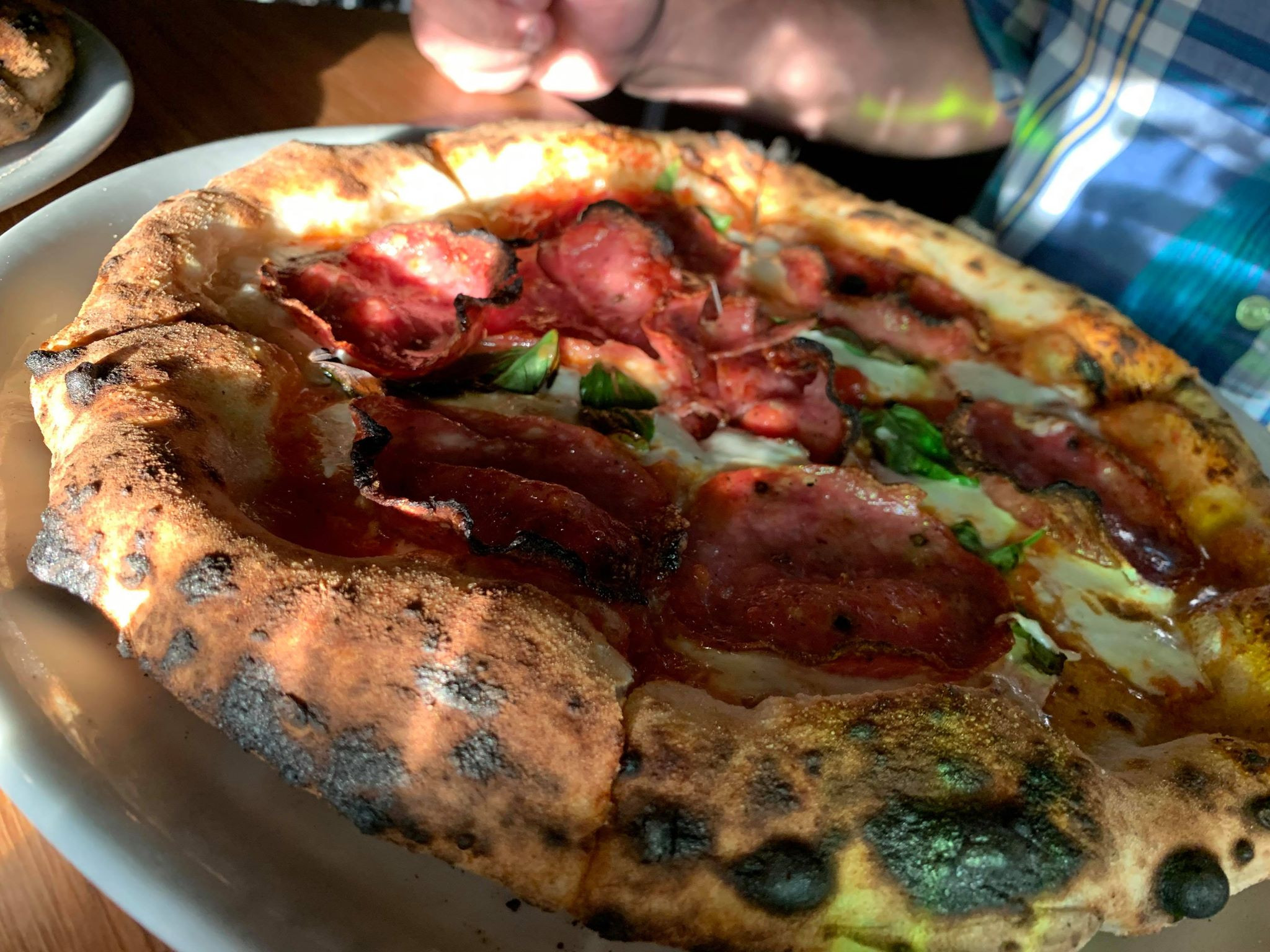 Close-up photo of A Dopo Salami pizza highlighting the sourdough crust and fresh toppings