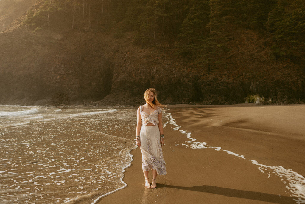 girl in white dress standing on a beach at the Oregon coast