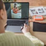 Photographer reviewing images on a laptop, symbolizing image analysis and authenticity checks