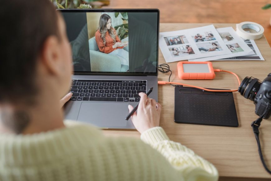 Photographer reviewing images on a laptop, symbolizing image analysis and authenticity checks