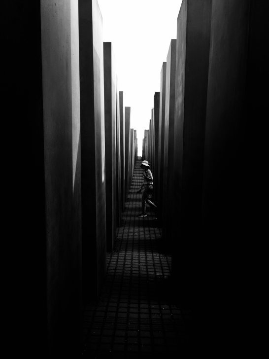 Black and white street photography scene focusing on a person walking with a clean, uncluttered background