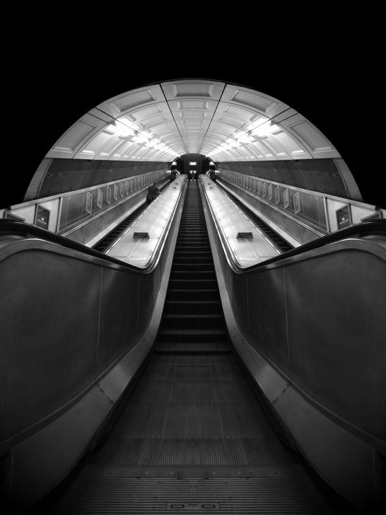 Black and white photograph capturing movement in a train station, utilizing burst mode for sharp results