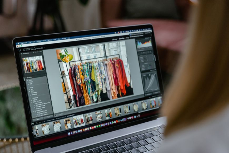 A woman looking at a laptop screen, focusing on the details of an image, representing the close examination needed to detect photo manipulation