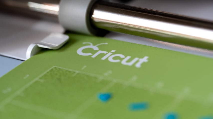 A Cricut machine cutting a design.