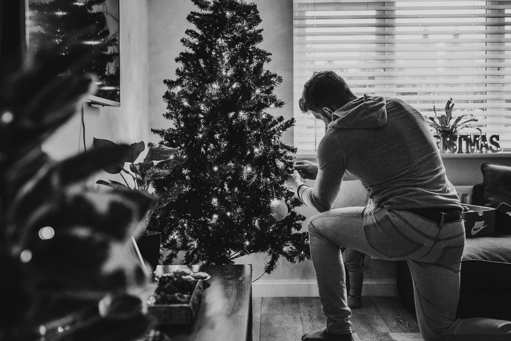 A family scene in landscape orientation, capturing the Christmas tree and decorations, showing the benefit of landscape mode for DIY Christmas photos.