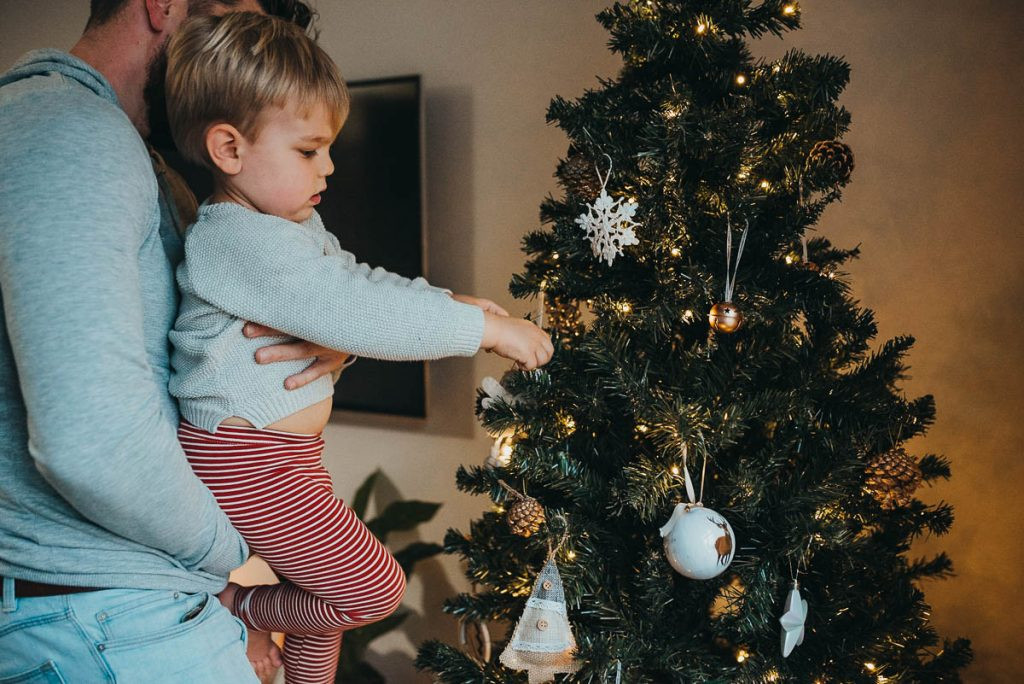 A candid shot of a child naturally interacting with Christmas decorations, highlighting the beauty of unposed DIY Christmas photos.