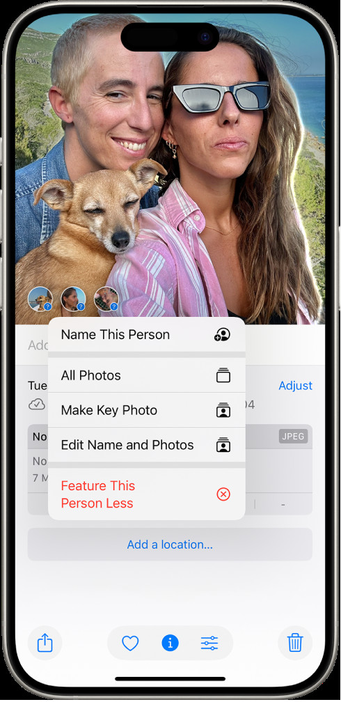 Naming a person from a photo detail view on iPhone Photos app. A photo is open, and in the bottom left corner, a question mark is selected next to a detected face, prompting the "Name This Person" option.