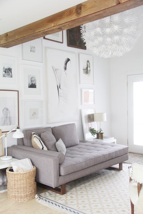 alt text: An eclectic gallery wall featuring a mix of framed family photos and artwork, showcasing a variety of frame styles and sizes.