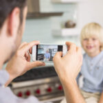 Father taking photo of child at home