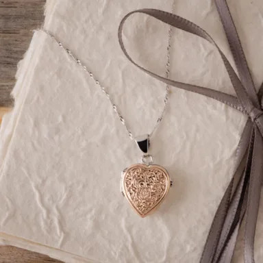 A heart-shaped locket in white and rose gold, presenting a romantic design and photo space, perfect for sentimental photo keepsakes