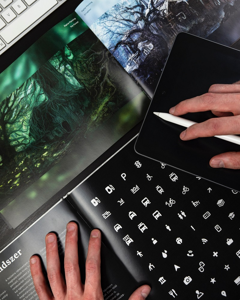 A person reviewing digital designs on a tablet, focusing on visual elements and layout.