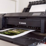 A Canon PRO-300 photo printer sits on a shelf.