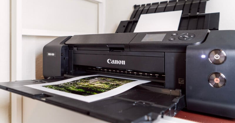 A Canon PRO-300 photo printer sits on a shelf.