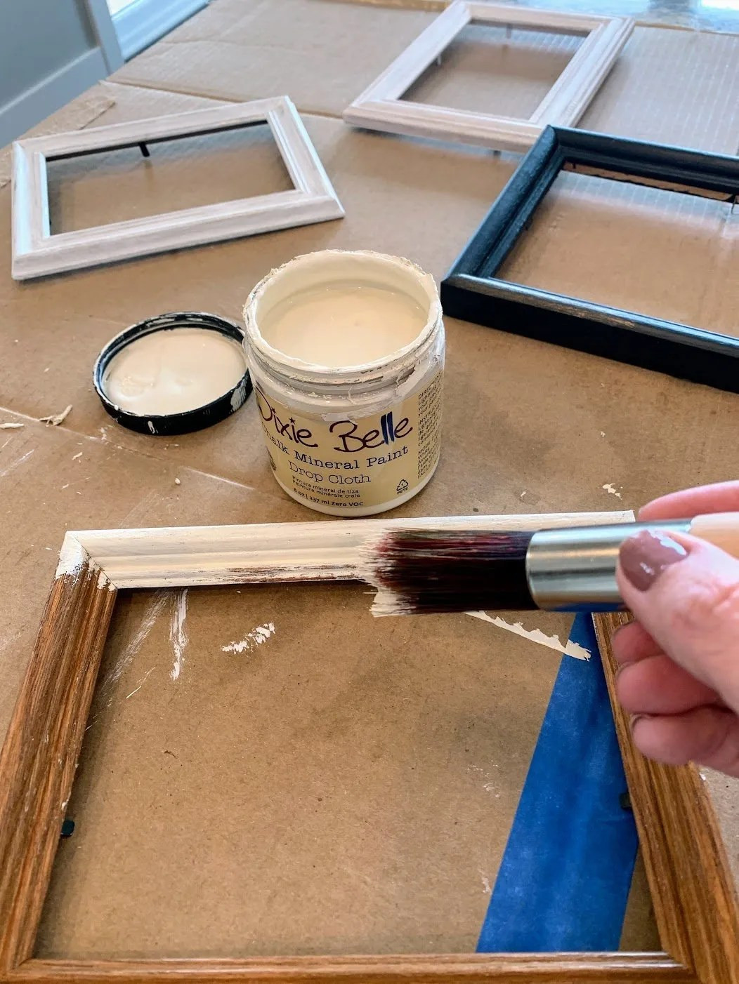 Painting a picture frame with a small brush.