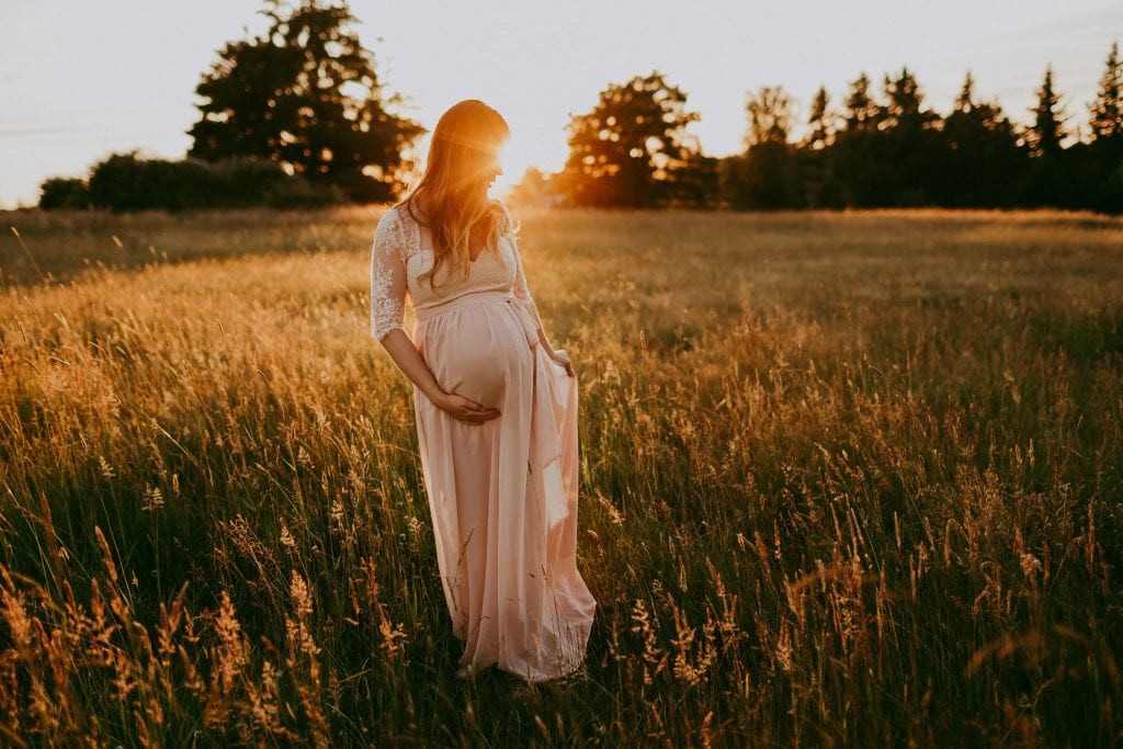 maternity photo of mama wearing a lace pink dress