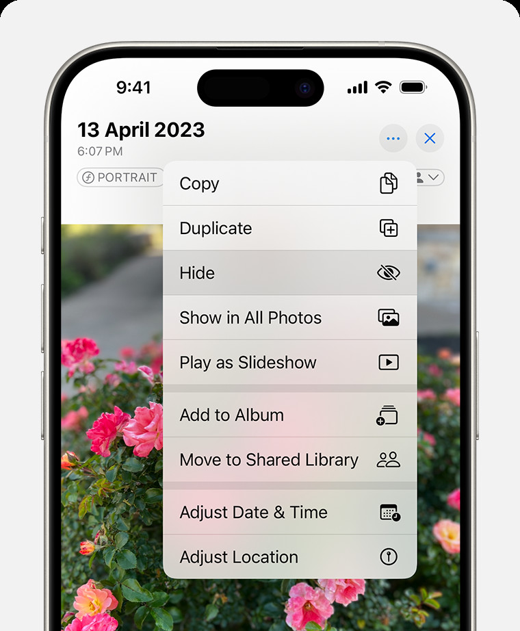 Tapping the hide option from the more menu on an iPhone to hide a photo.