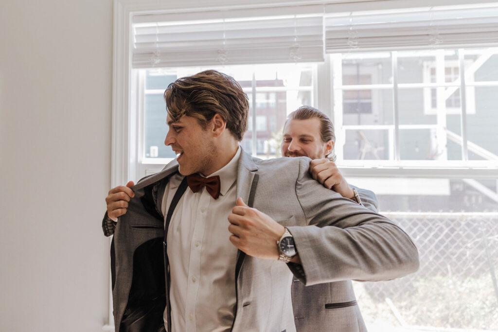 Candid photo of the Wilmington NC wedding groom laughing with groomsmen before the ceremony