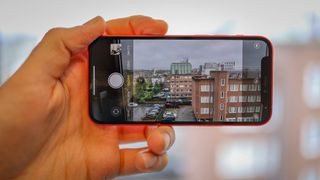 A person testing the camera of iPhone 12 mini, highlighting manual control in iPhone photography.