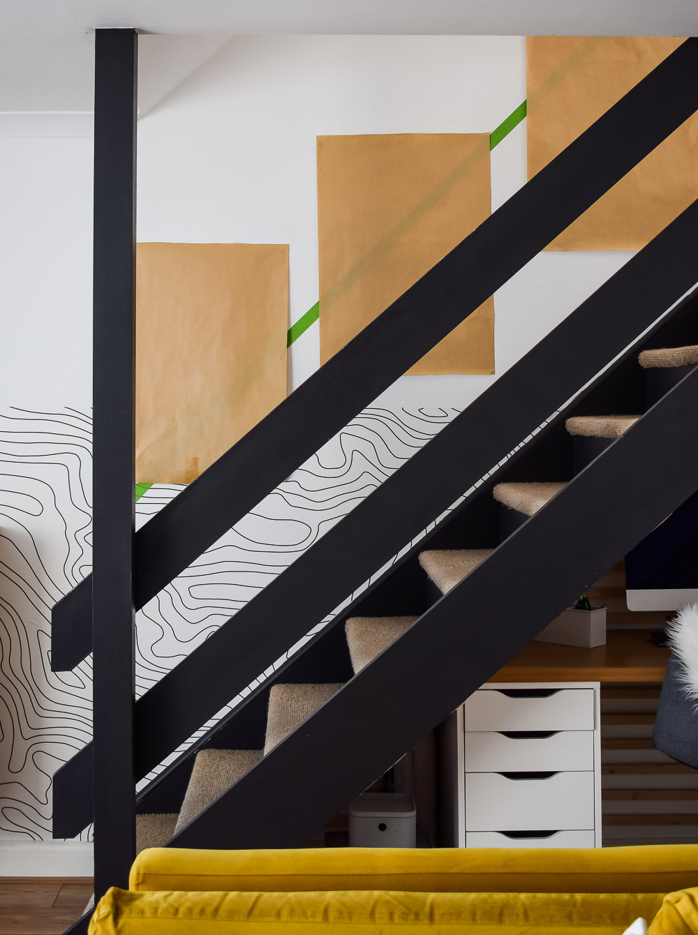 Kraft paper frame cutouts arranged on a staircase wall to visualize a gallery wall layout