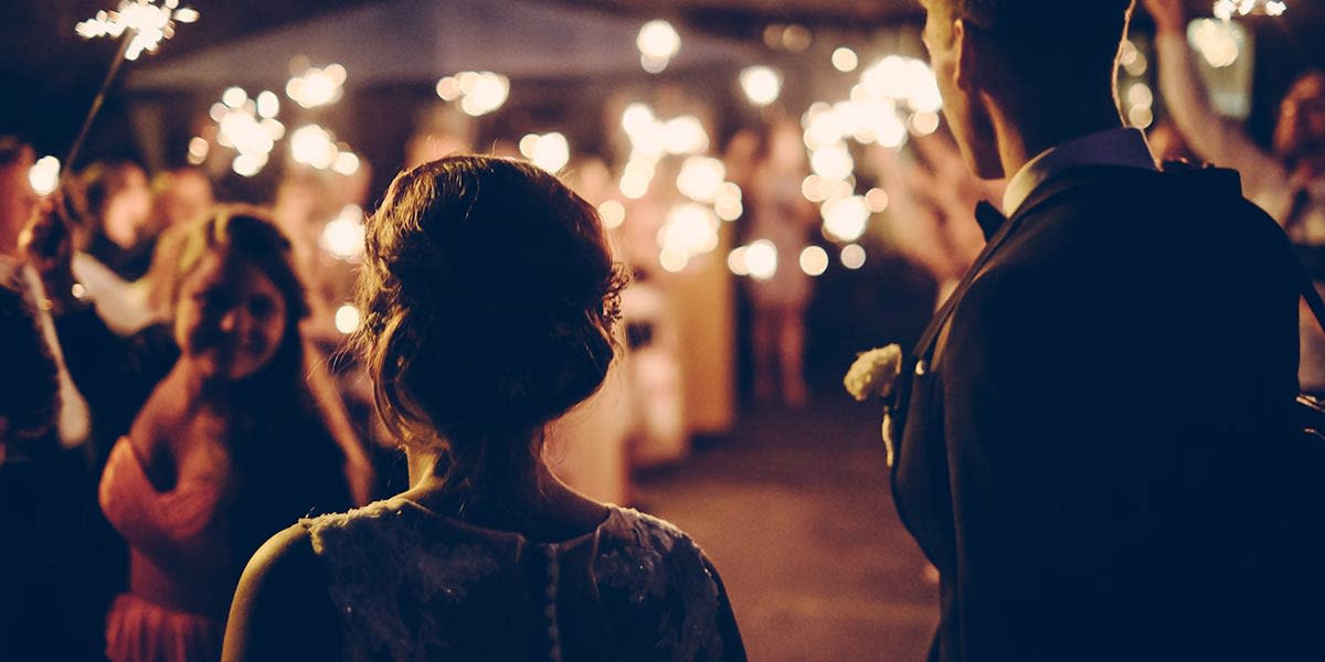 A couple walking with sparklers, with bokeh in the background, demonstrates how selective focus enhances subject prominence in professional photography.