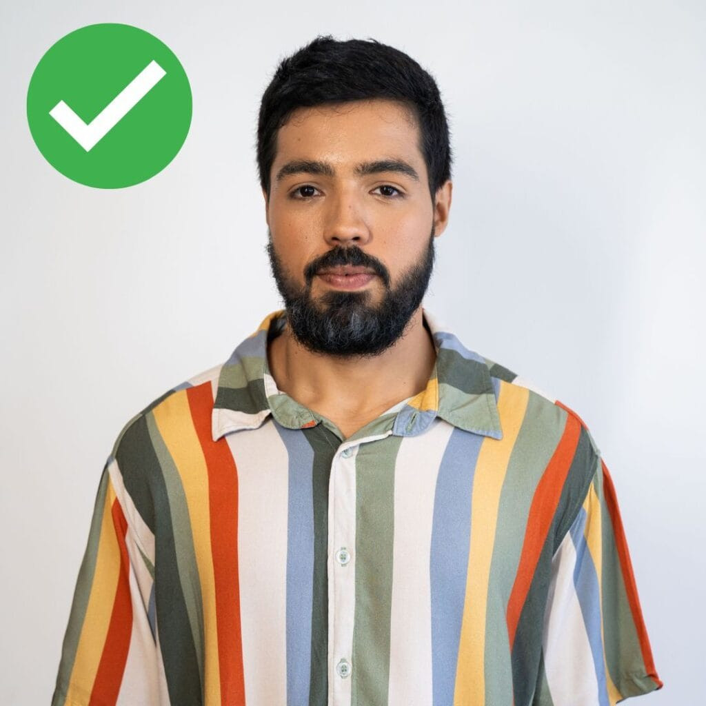 correct passport photo of a man looking directly to camera with a neutral expression and background
