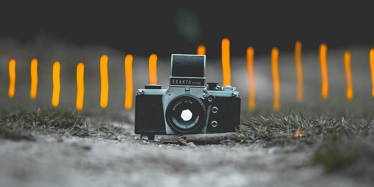 An old SLR camera with a blurred background emphasizes the focal point, illustrating the importance of subject selection in professional photography.