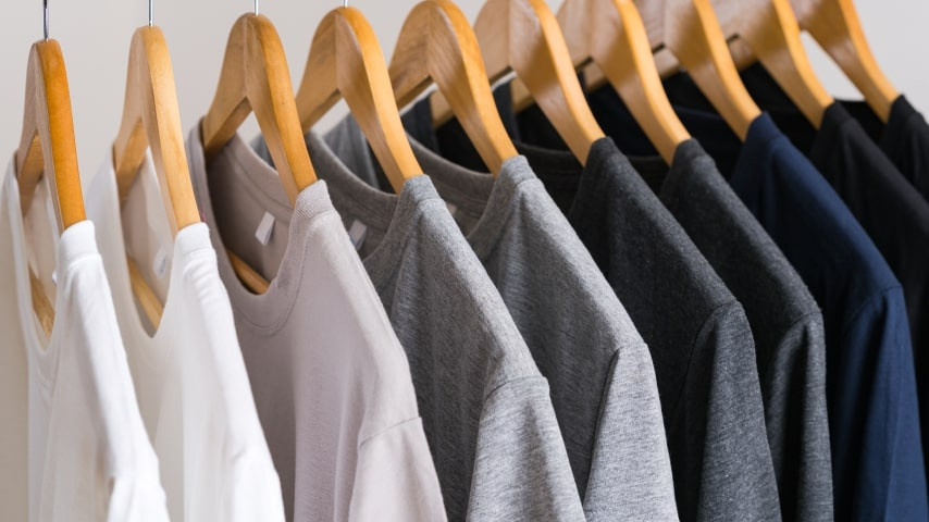 Different colored t-shirts on a rack.