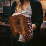 Lady carrying a pile of new trifold wallets