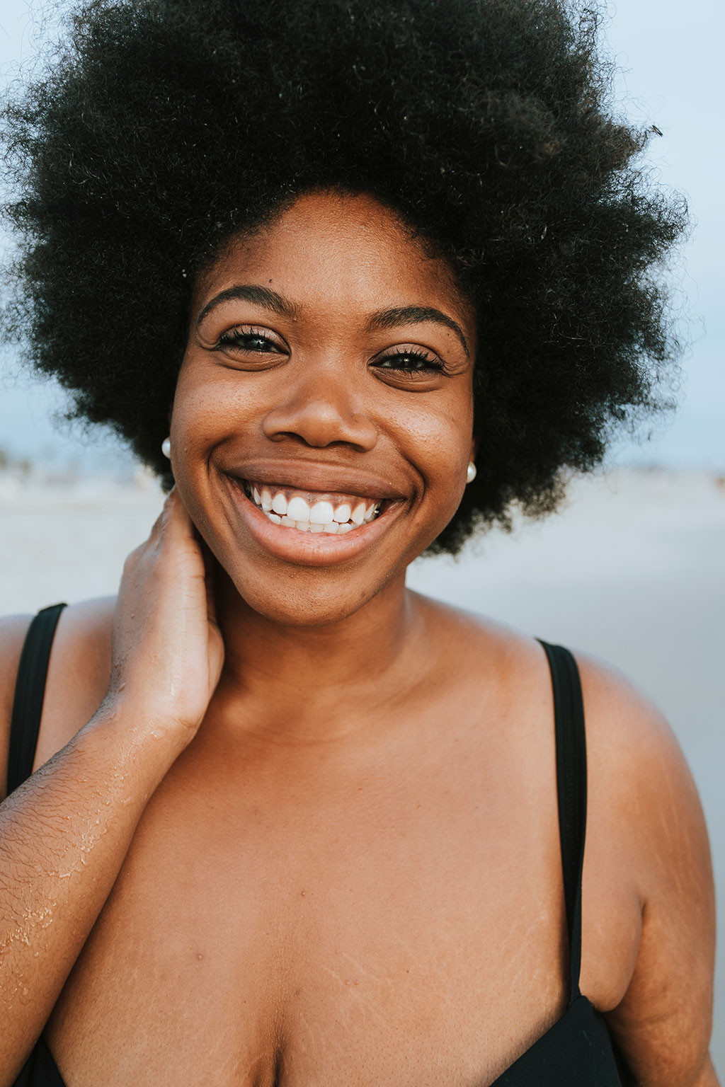 Beautiful Plus Size Model smiling on a beach, showcasing body positivity in stock photography