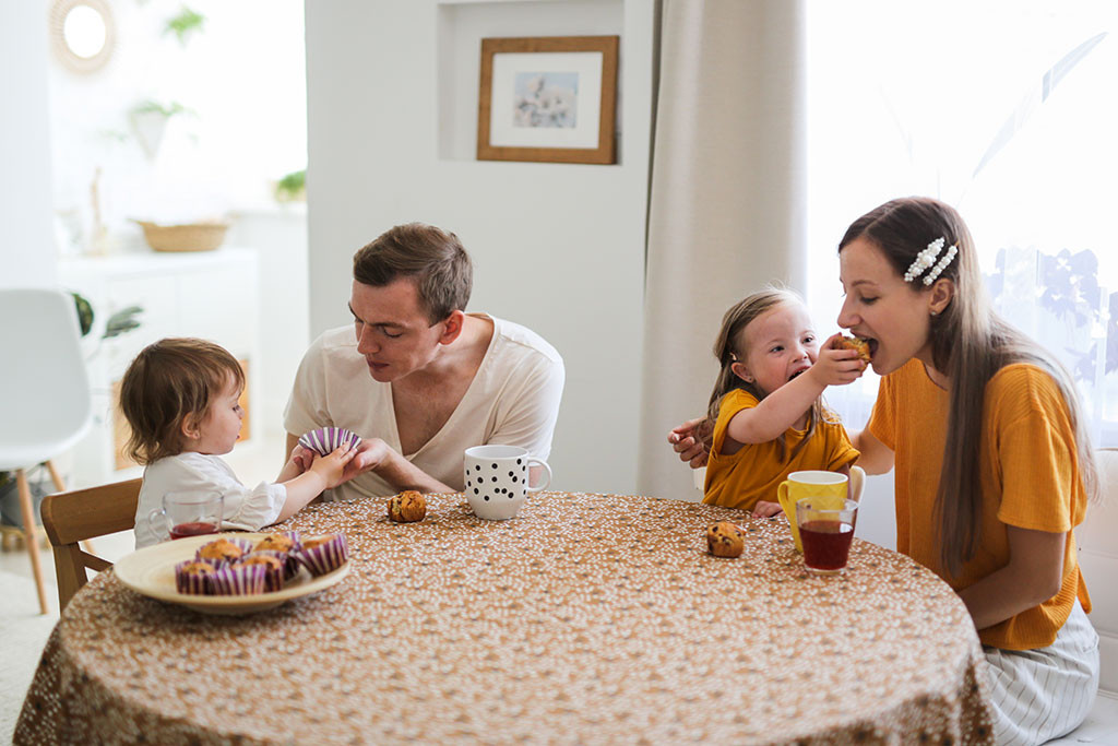 Family having breakfast with a child with Down Syndrome, promoting inclusive family imagery in stock photography