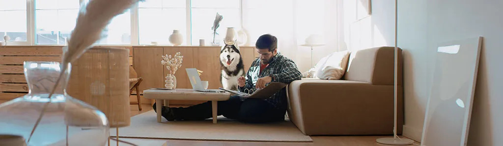 Man working from home with his dog, illustrating the modern work-life balance in stock photography
