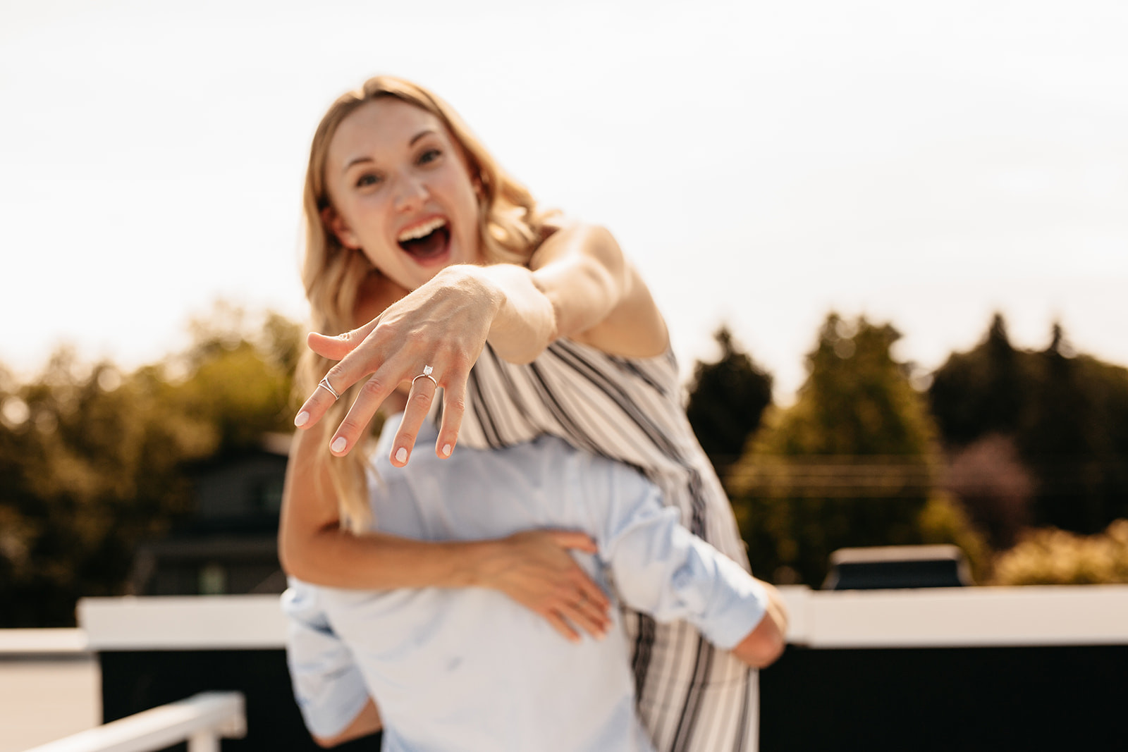 Woman showcasing her engagement ring, highlighting the focus on the engagement itself