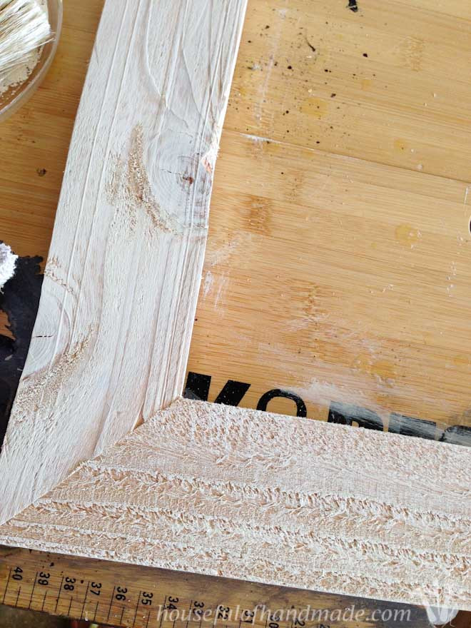 Rustic frames being painted with a dry brush technique, emphasizing the wood's texture for a rustic finish.