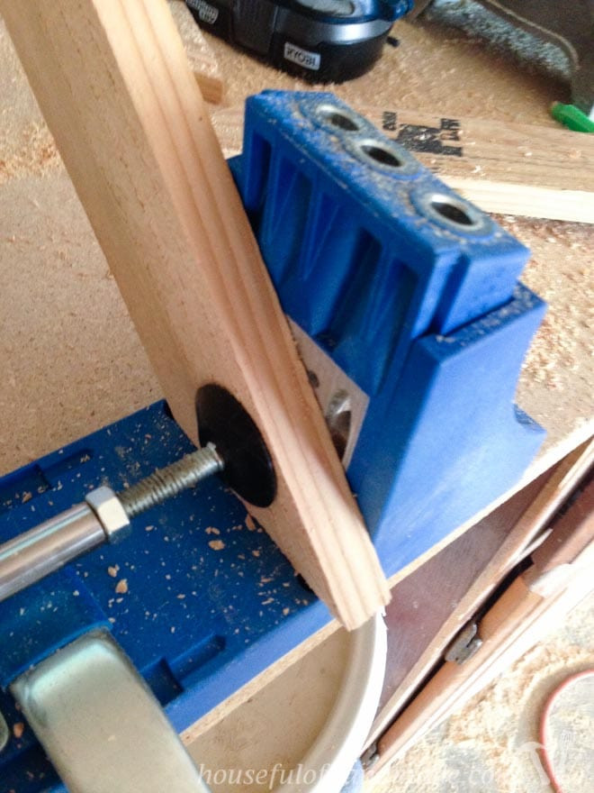 Wood being prepared with a Kreg jig, used for creating pocket holes in DIY wood frame construction.