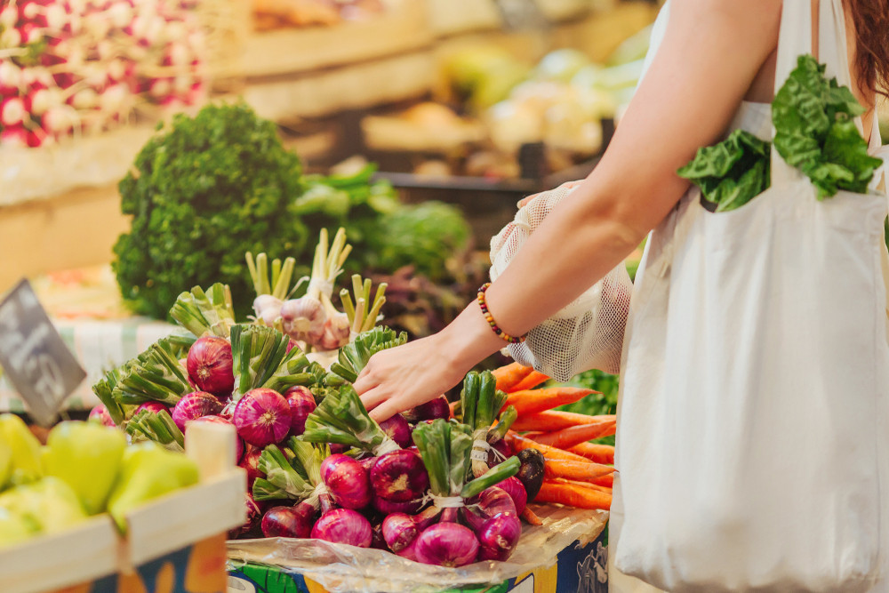 Woman choosing fresh produce at a vibrant outdoor market