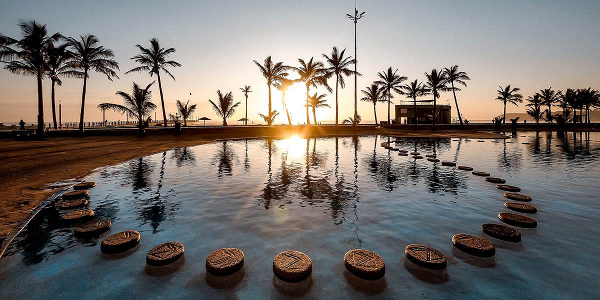 Sunset at a beachside pool, capturing warm light and silhouette effects