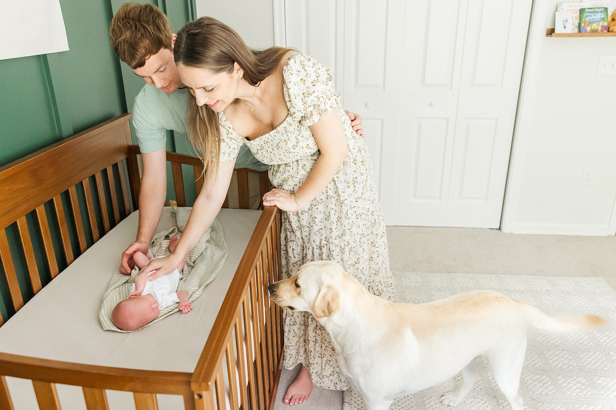 alt text: Dog looking at baby in crib through the rails.