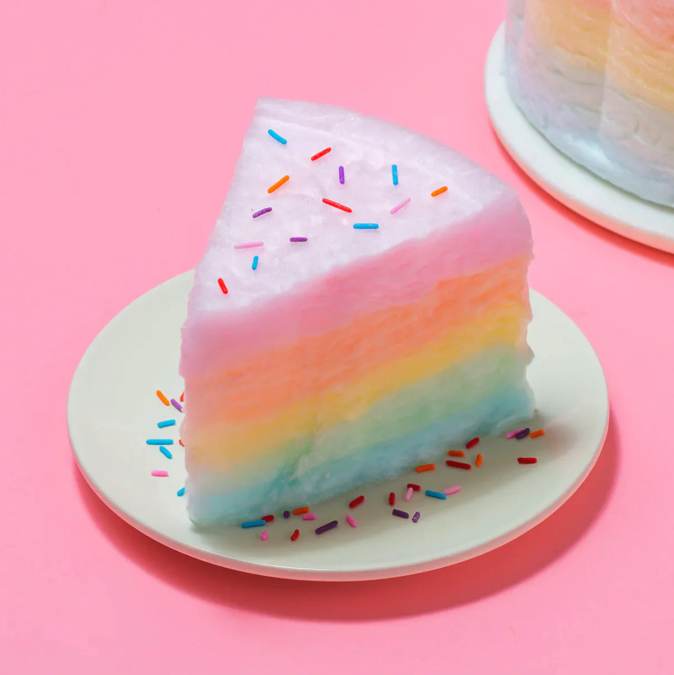 Floof's side-angle food photograph of a cotton candy cake slice highlights the cake's vibrant, colorful layers and creates a sense of depth.