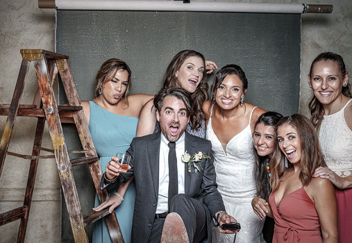 DIY wedding photo booth featuring a hand-painted backdrop and open space for group photos