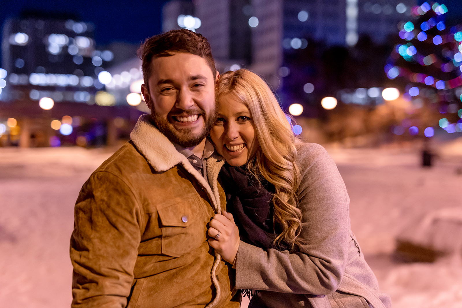 Couple embracing in winter setting, capturing a moment shortly after proposal