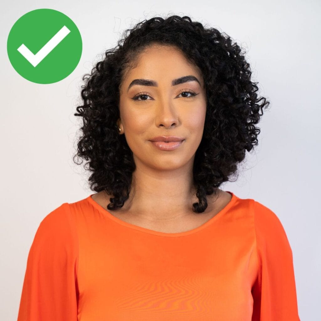 correct passport photo of a woman looking to camera with a neutral expression
