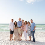 Family in coastal attire with floral print dress for beach photoshoot