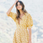 Woman in white dress standing in a field with a blurry background